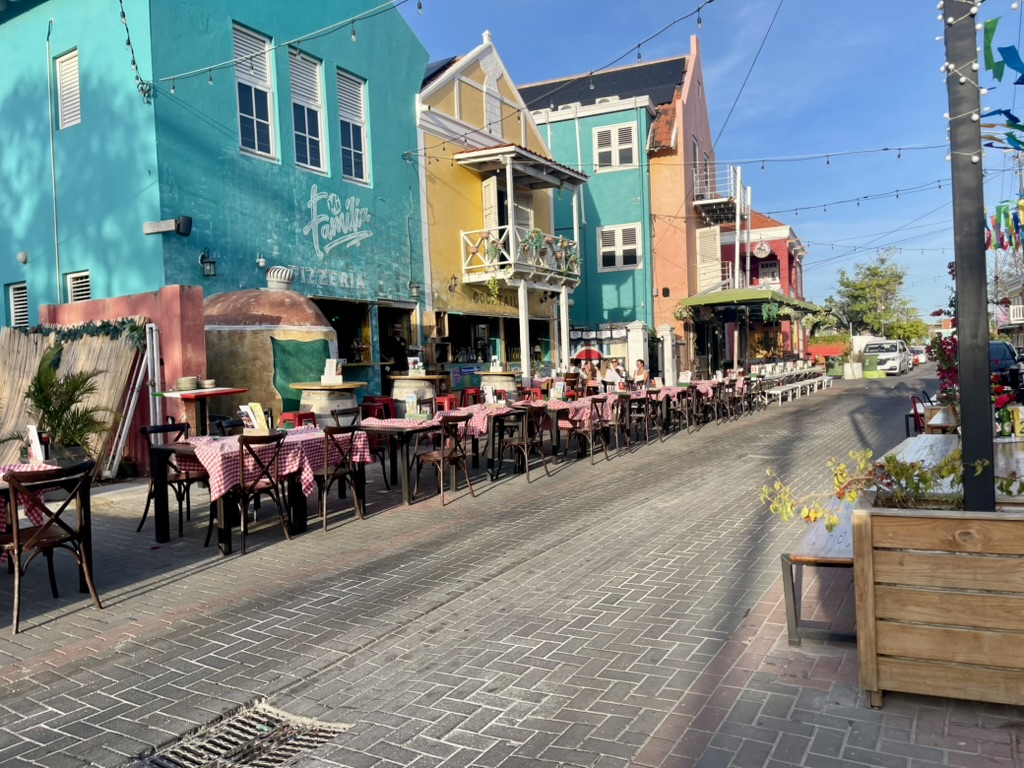 Colorful Pietermaai street with pastel buildings and outdoor restaurant tables