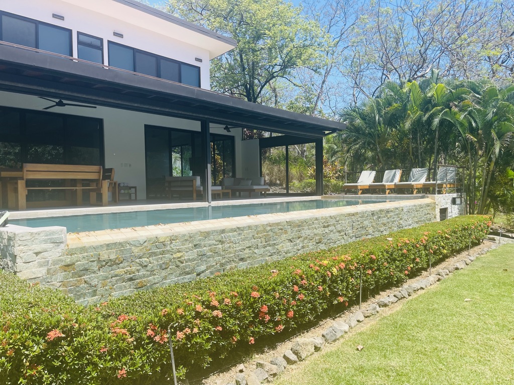 Modern villa with an infinity pool, stone terrace and tropical gardens at Tierra Pacífica in Junquillal, Costa Rica