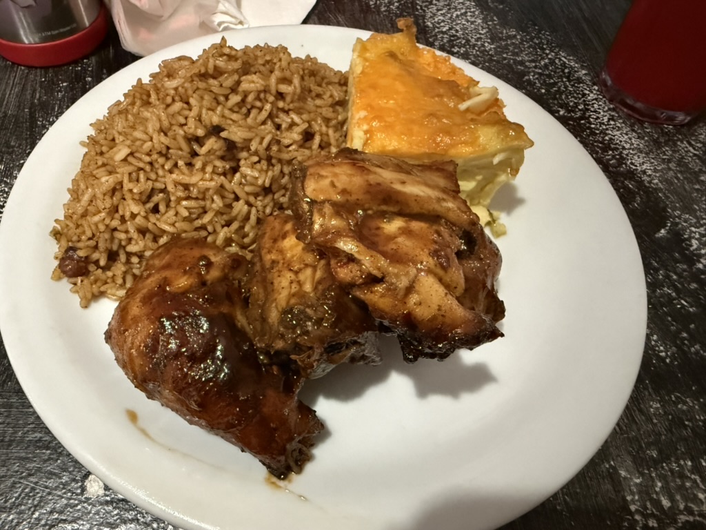Plate of jerk chicken with peas and rice and baked macaroni at Twin Brothers