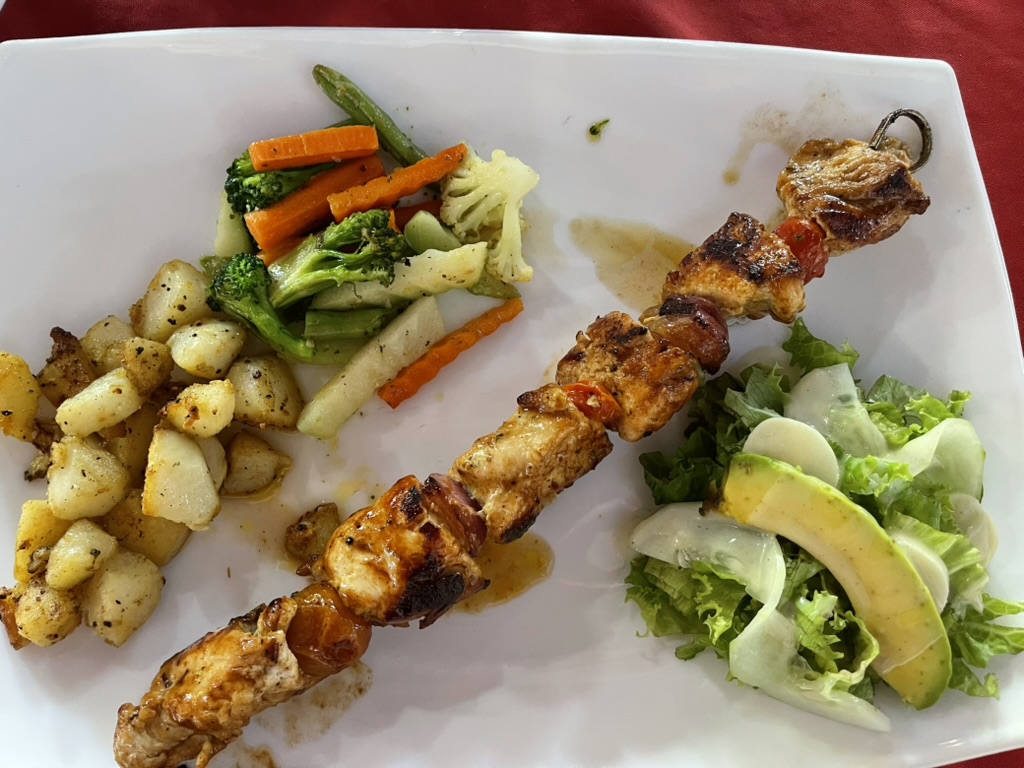 A grilled chicken skewer with vegetables, potatoes and fresh salad at Restaurante Lochito's in Playa Junquillal, Costa Rica