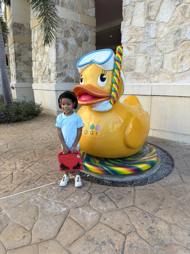 Preston standing beside the giant rubber duck sculpture outside Sugar Factory