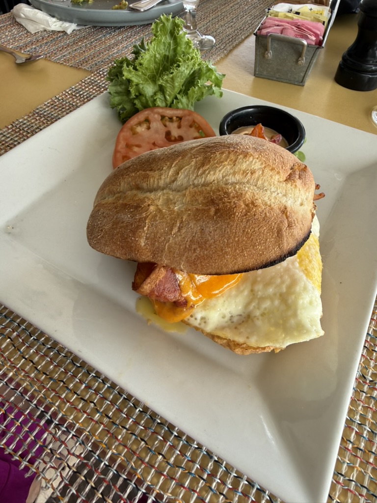Breakfast sandwich with egg, bacon and cheese on a crusty roll