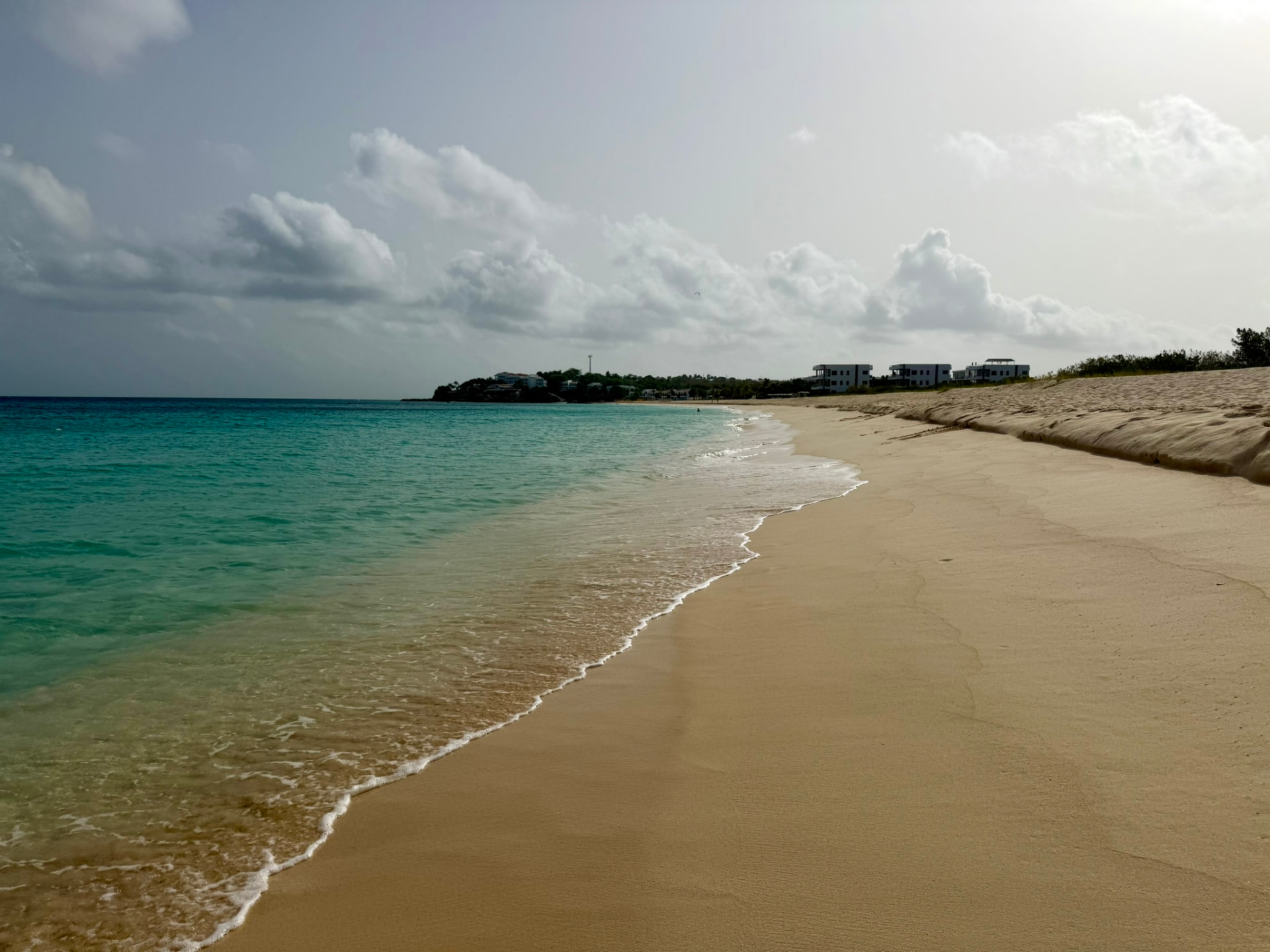 Empty stretch of Meads Bay shoreline with turquoise water and soft cloud cover