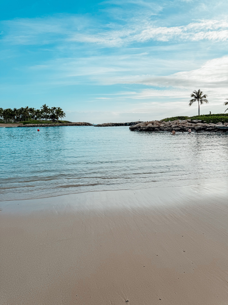 Shallow, clear water at the edge of a protected Ko Olina lagoon with soft sand