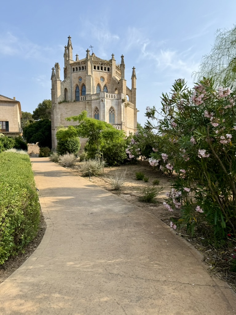 The neo-Gothic chapel on the Zoëtry estate seen from a garden path lined with oleander in bloom