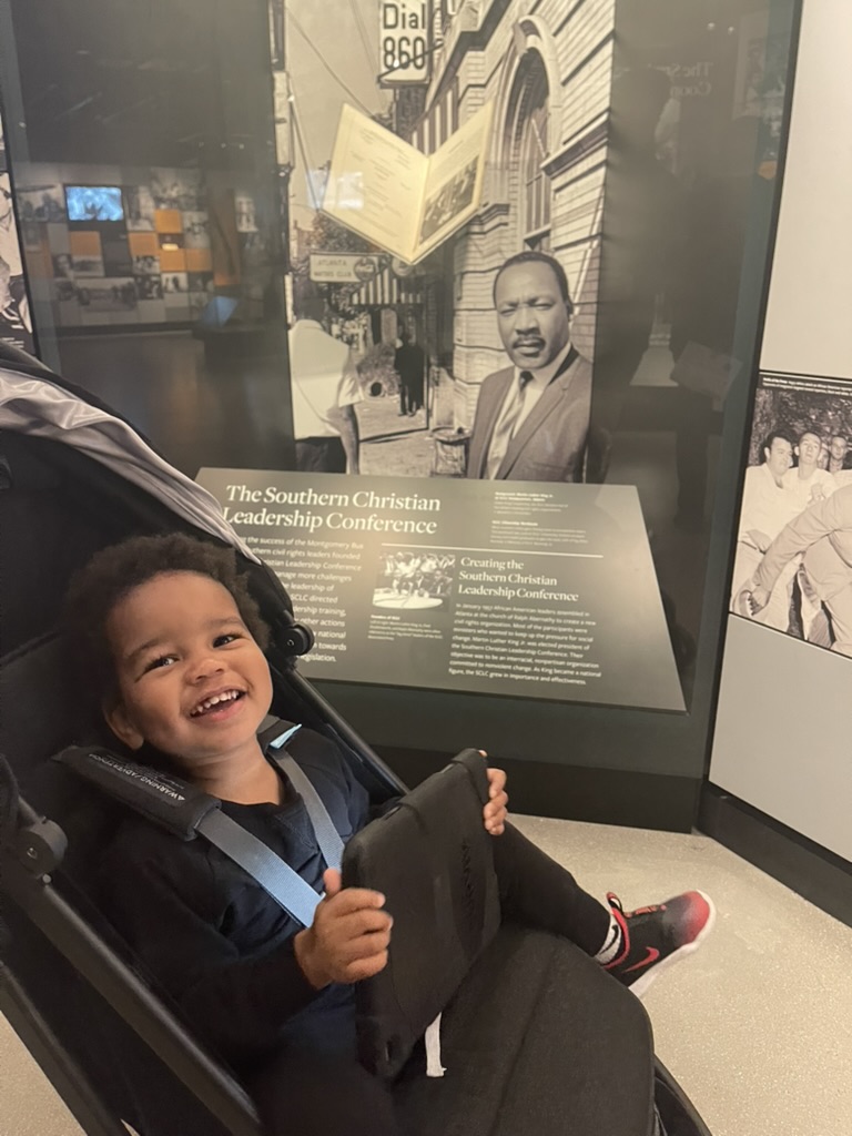 Toddler smiling in a stroller at the National Museum of African American History and Culture