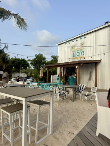 Outdoor tables and stools in the sand outside Leon's