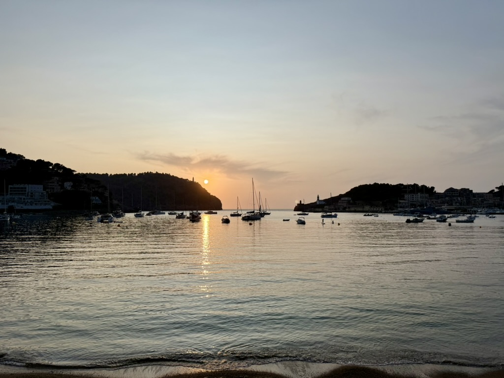 Sunset over Port de Soller with sailboats anchored in the calm harbor