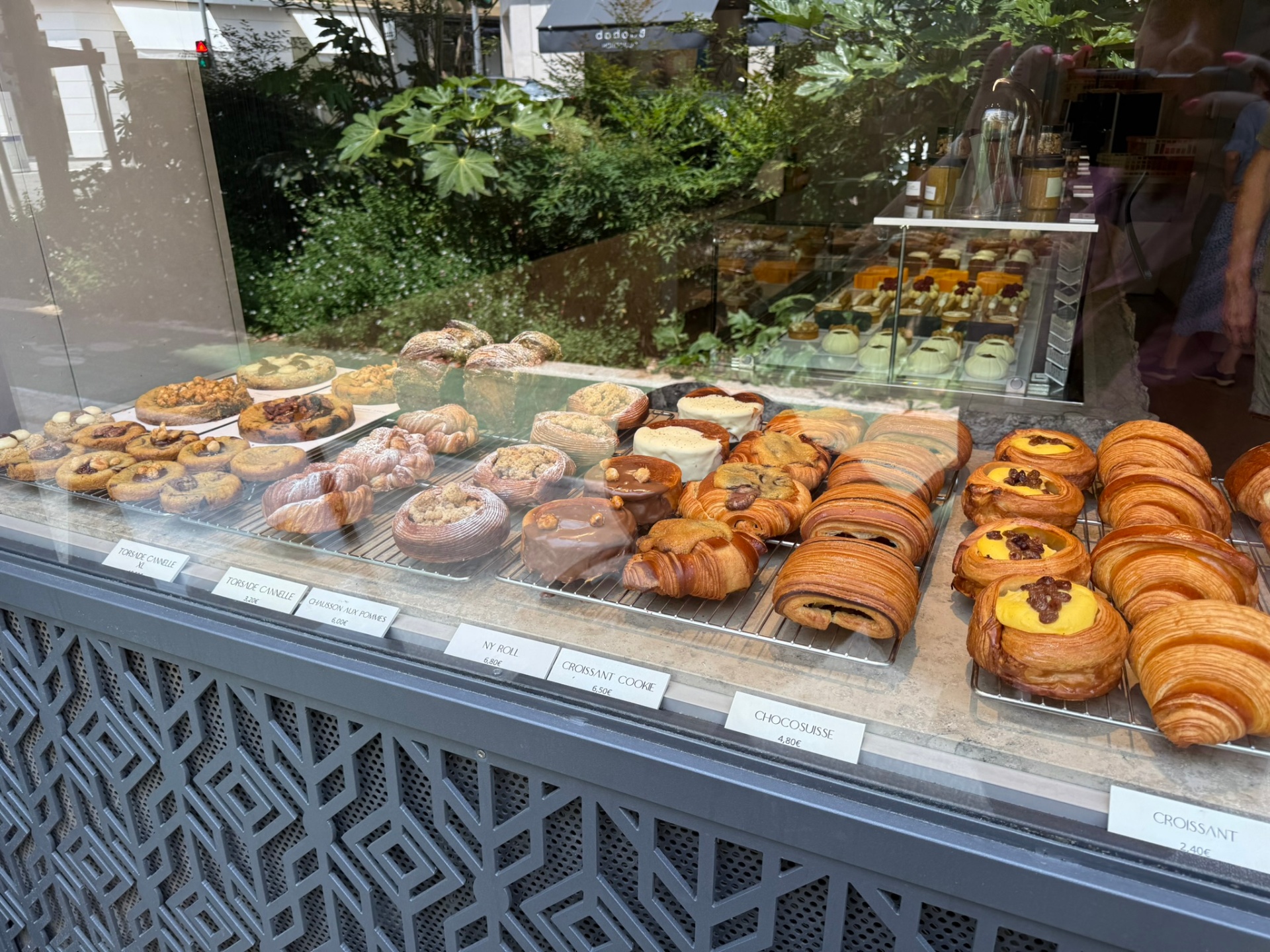 A bakery display case filled with croissants, pastries, and tarts in Nice.