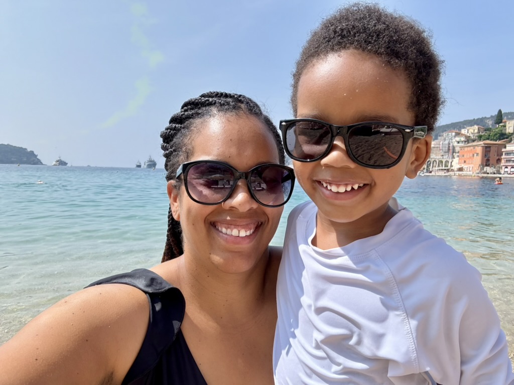 Mother and son in sunglasses smiling for a selfie in the turquoise water at Villefranche-sur-Mer