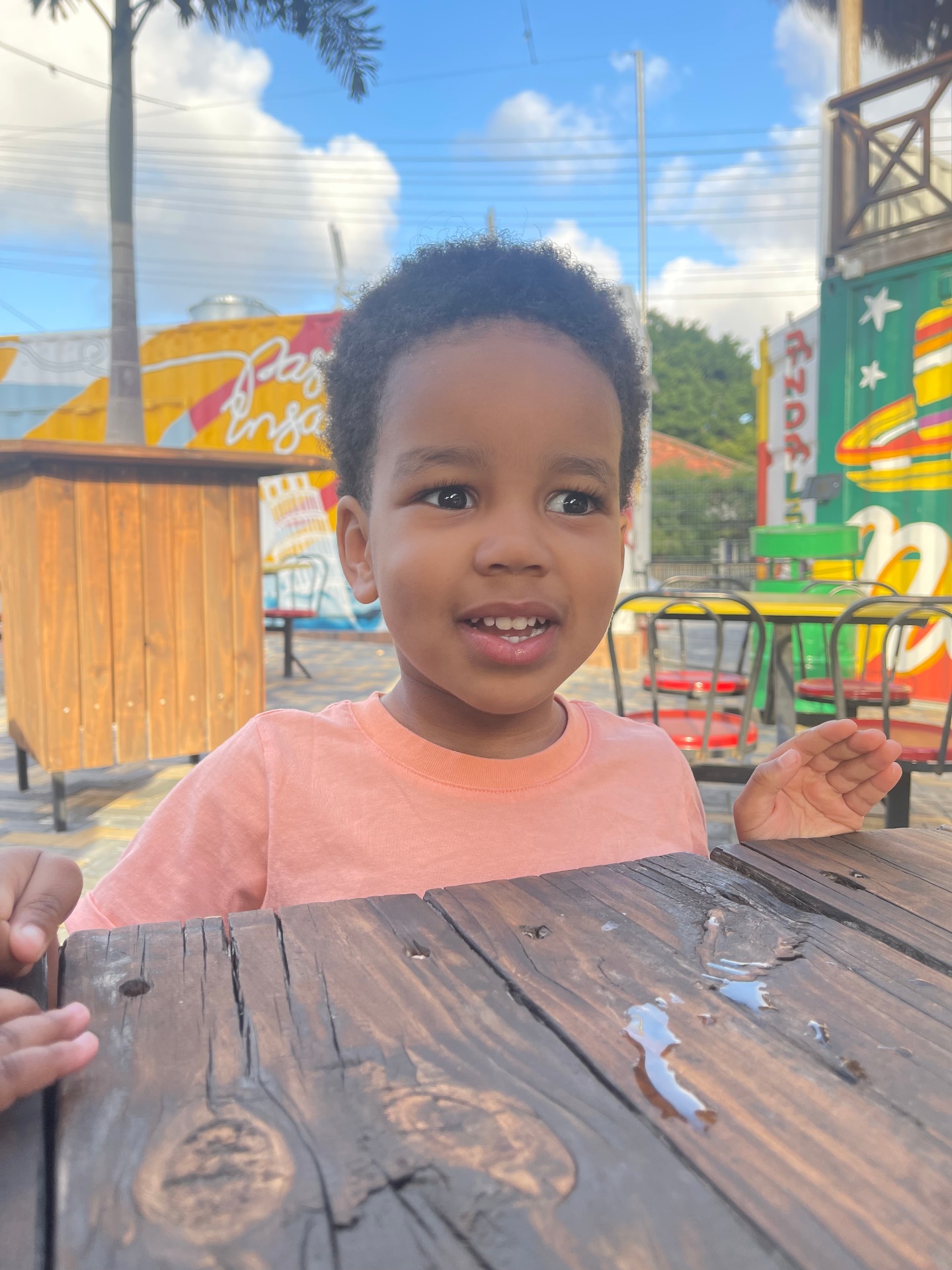 A child in a pink shirt at colorful food trucks in Curaçao