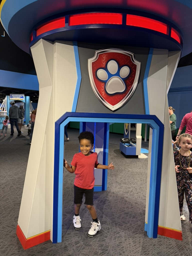 Preston standing in the doorway of the PAW Patrol Lookout Tower, smiling with both thumbs up