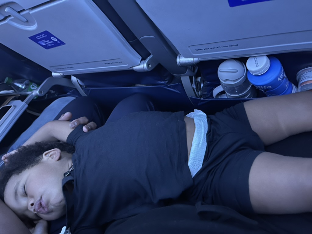 Preston asleep across airplane seats on the flight to Costa Rica