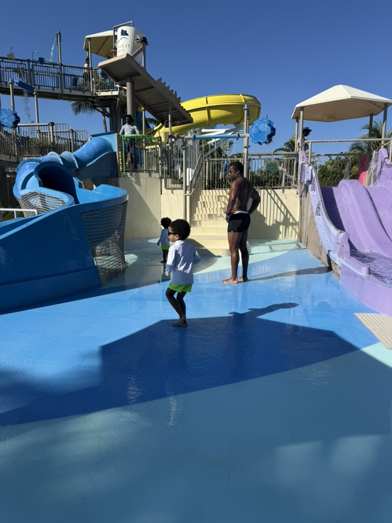 The boys and Dad at the base of the bigger slides in Stingray Cove