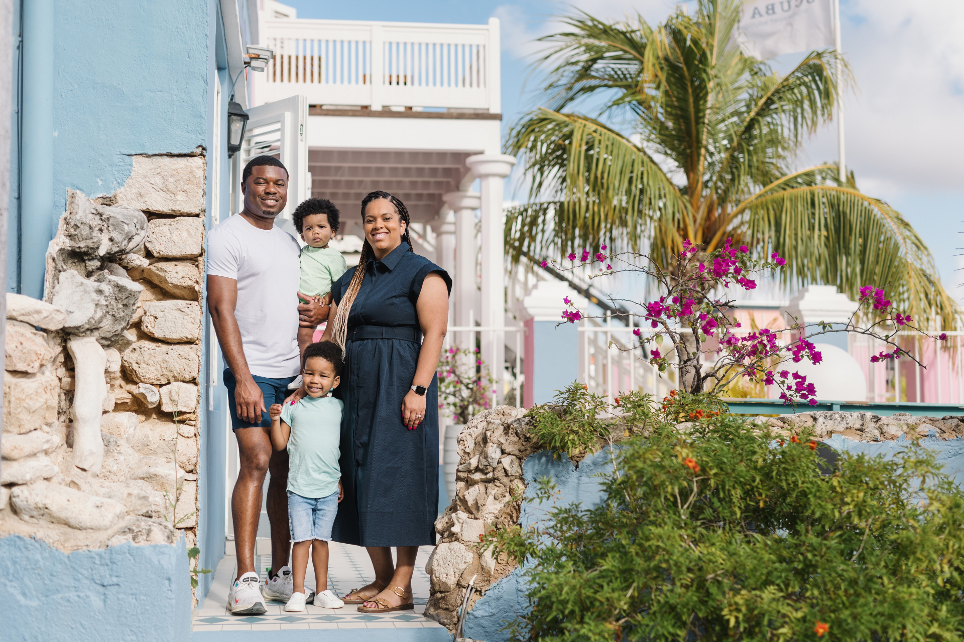 Our family of four on the steps of a pastel blue building in Curaçao