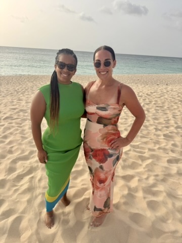 Two friends standing together on the beach at dusk