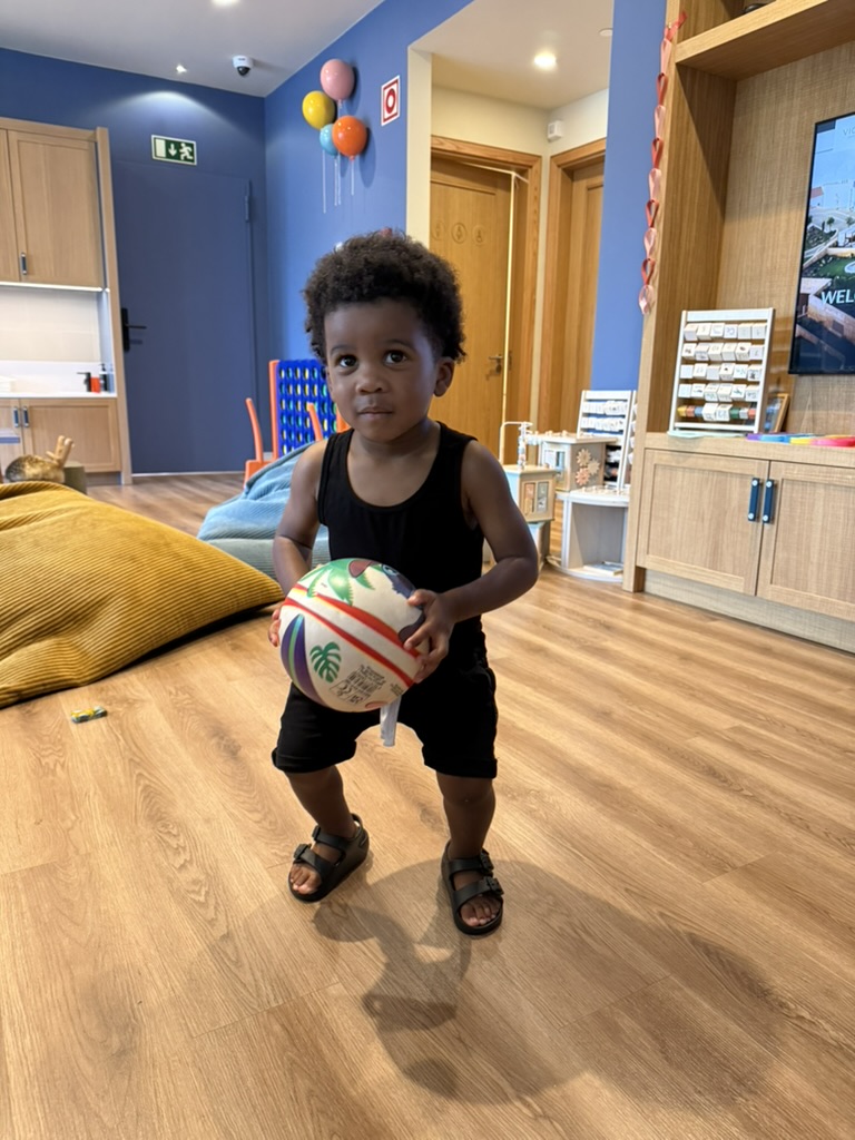 Toddler holding a ball in the resort kids' club playroom