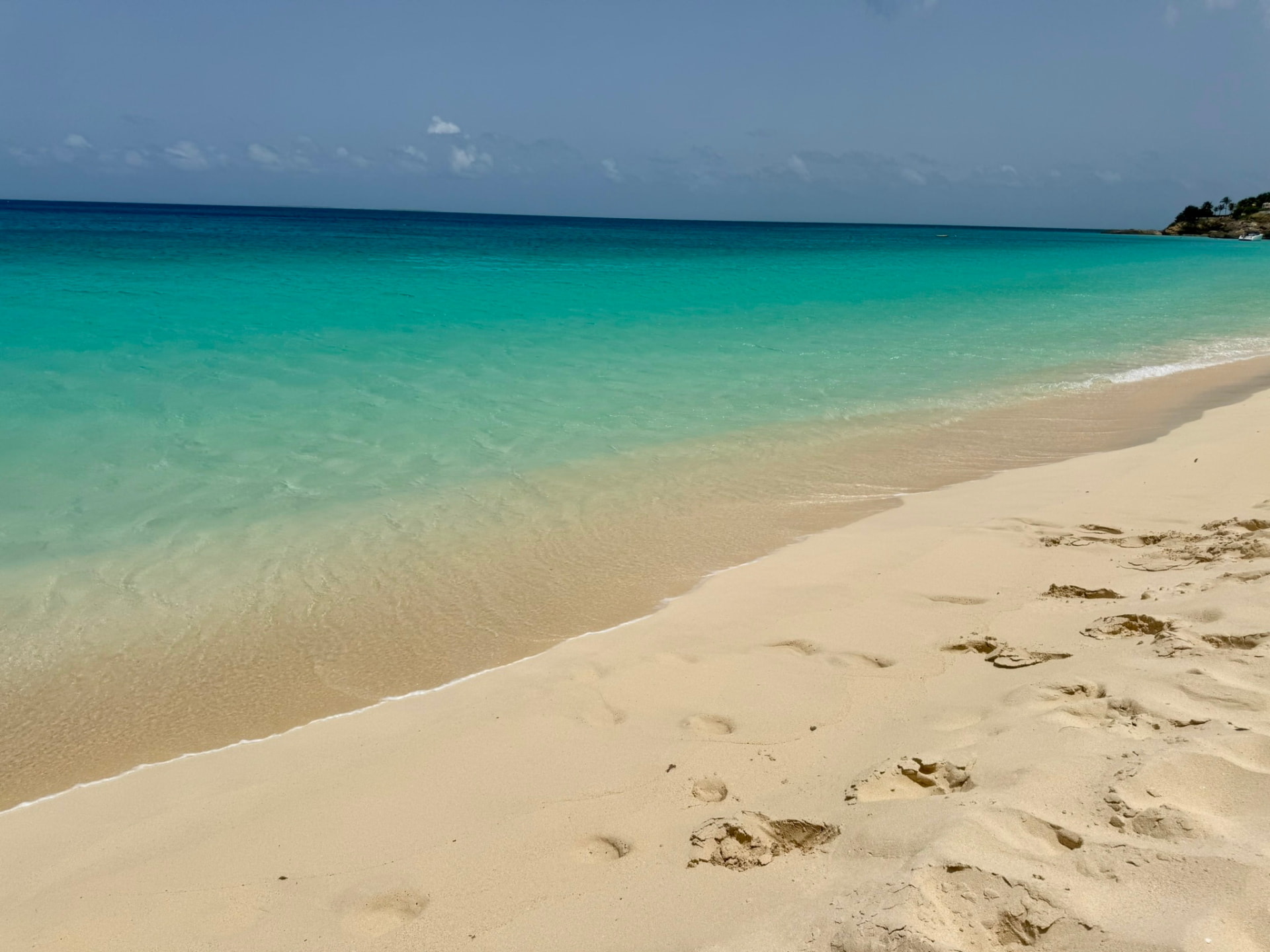 Clear turquoise water meeting soft pale sand on an empty stretch of Meads Bay
