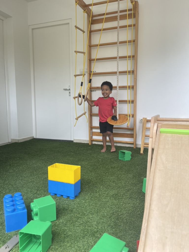 Child playing on indoor climbing wall with rings and building blocks